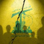 Yellow wall with cracked logo and shadowy figures