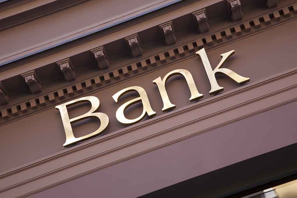Gold bank sign on building facade