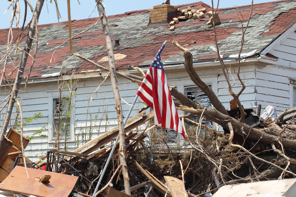 78985747 featured image Damaged house with fallen tree and American flag