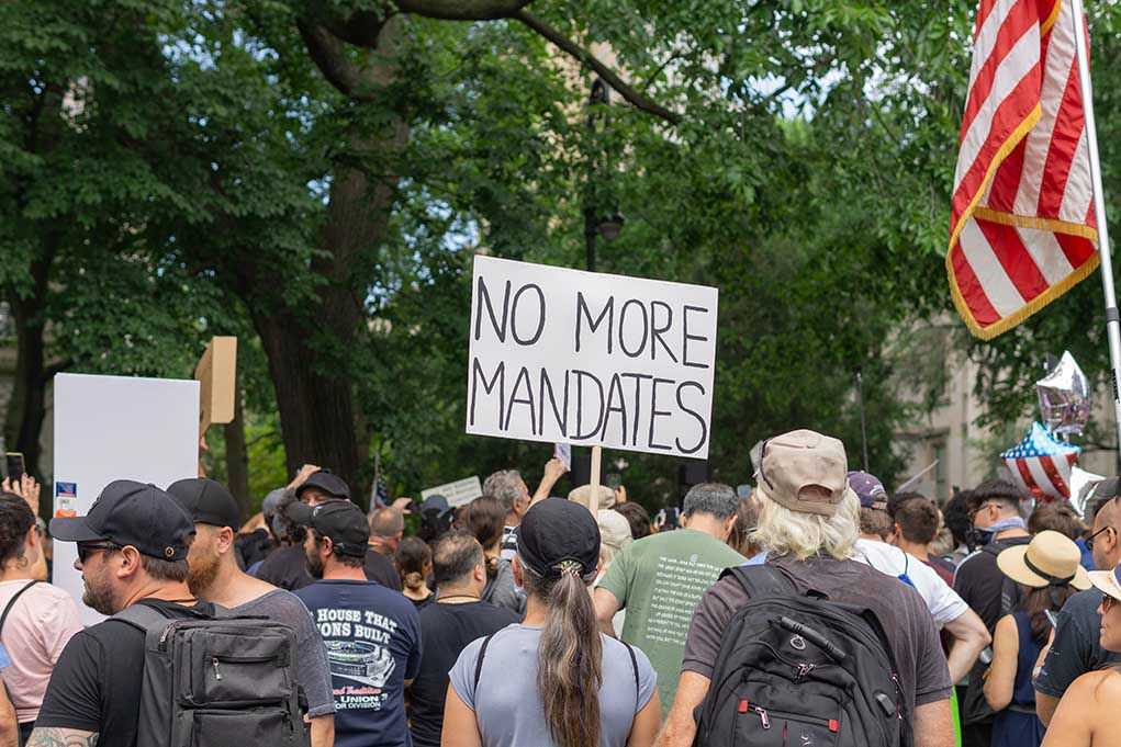 202226174 Crowd holds "No More Mandates" sign at protest.