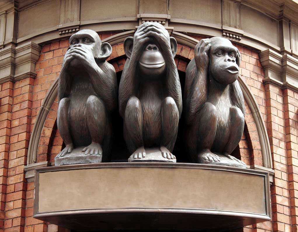 2749281 Three wise monkeys statue on a brick building
