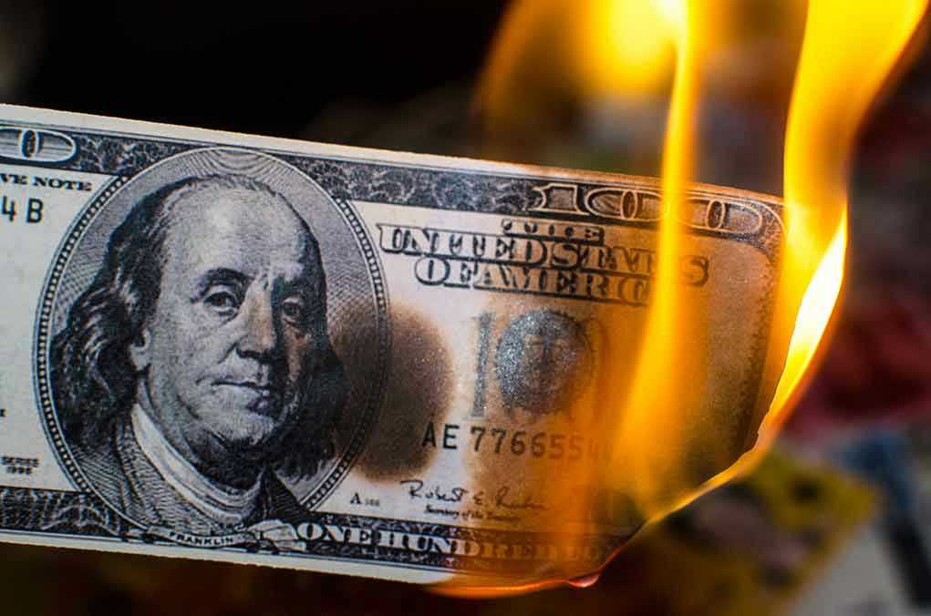 Burning hundred-dollar bill with visible flames