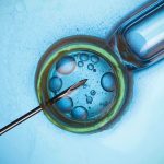 Pfizer Vaccine’s SHOCKING Eye Risk Exposed Close up of a needle and vial with liquid droplets on a blue background