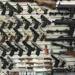 Fatal Shooting Triggers Massive Air Force Pistol Purge Wall display with handguns and rifles for sale.