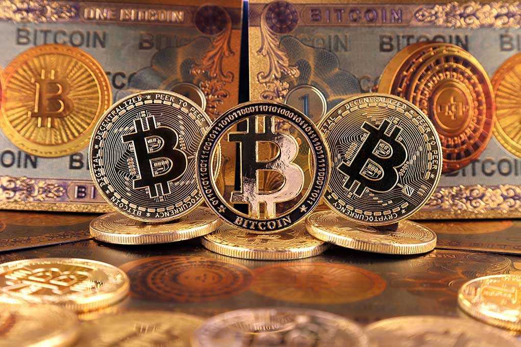 Bitcoins and Bitcoin themed banknotes in various designs