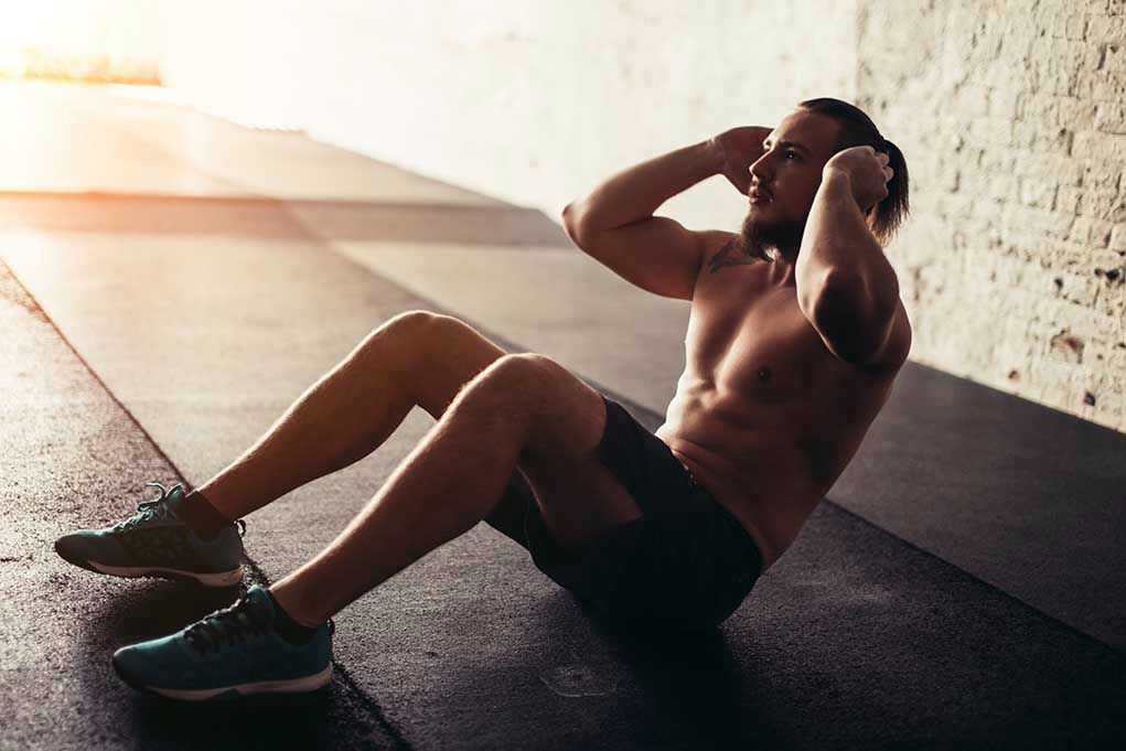 Man performing sit ups in a gym setting