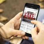 Staged Stabbing Sparks CHAOS—Colorado Shaken Person holding smartphone displaying fake news notification.