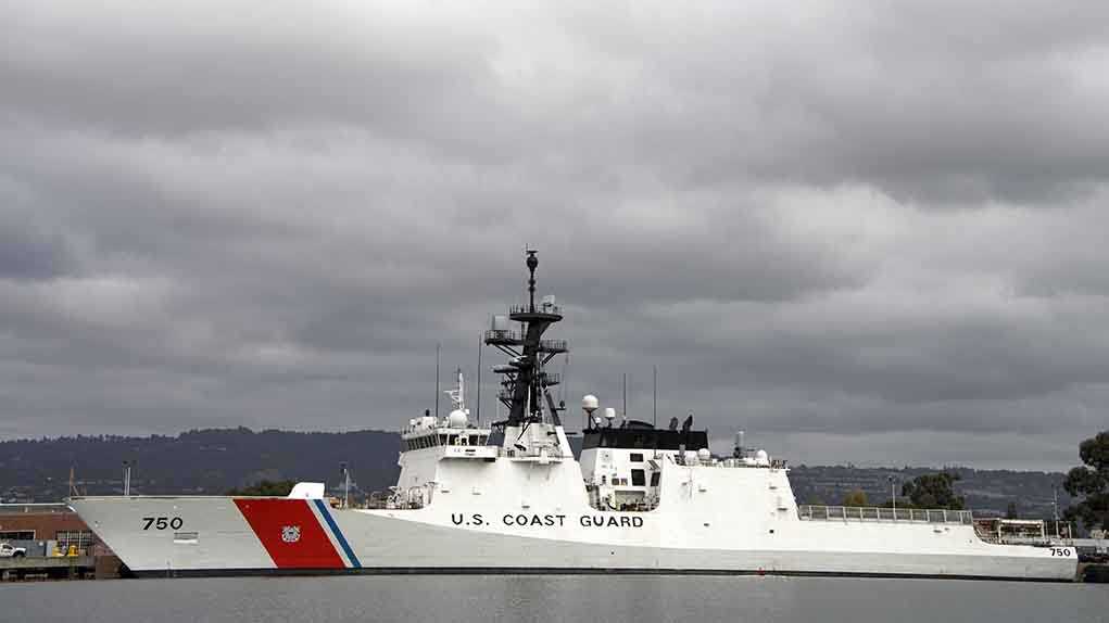 A U.S. Coast Guard ship docked under cloudy skies