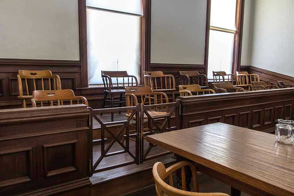 Empty jury box and table in courtroom.