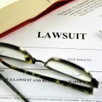 Lawsuit document with glasses, pen, and book.