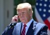Trump BLASTS Rep – Fight Turns Personal Man in a suit adjusting an earpiece.