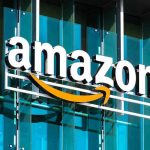 Amazon Slashes 30,000 Jobs—AI Replacing Workers! Amazon logo on a glass building facade.