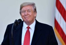 Trump Authorizes $230M Check—To Himself Man in suit and tie speaking at podium.