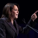 Kamala HINTS at Next Move – Dems Say NO! Person speaking at podium with raised finger.