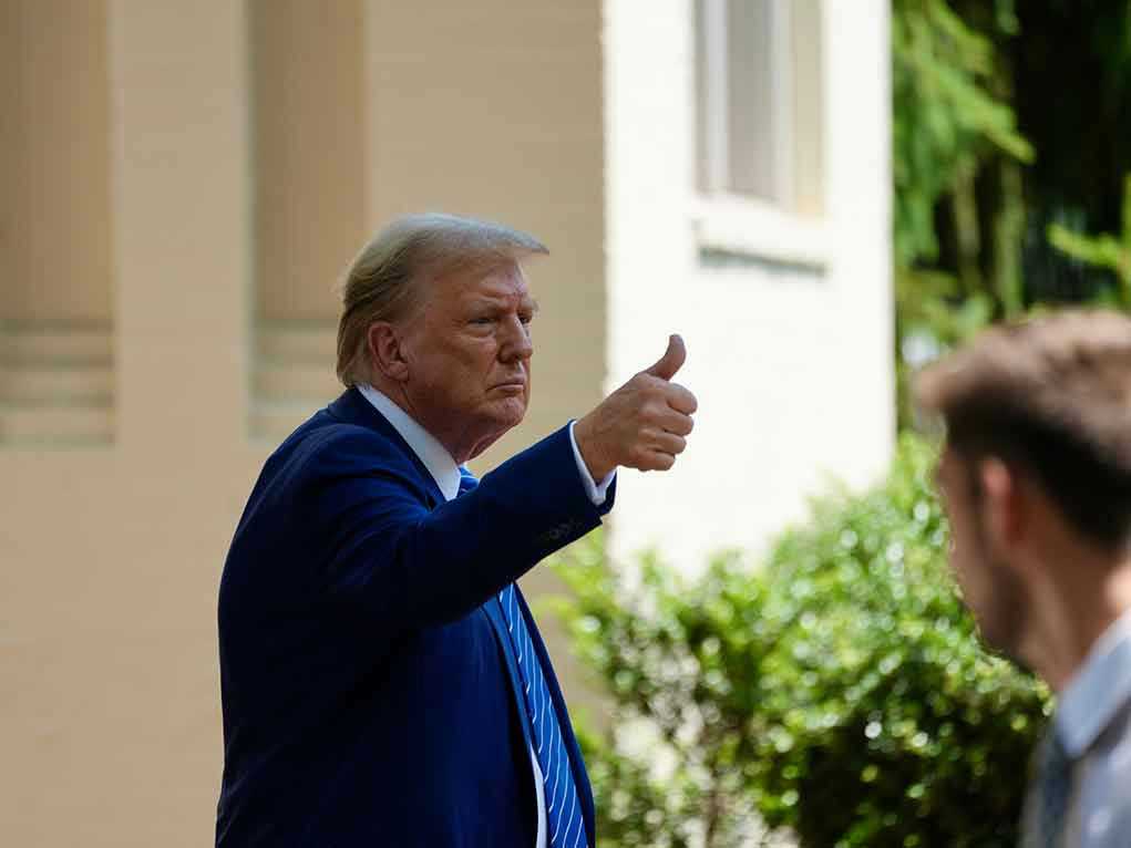 Man in suit giving thumbs up.