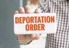 Trump SMASHES Deportation Record – He’s Not Done Hand holding sign with Deportation Order text.