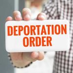 Trump SMASHES Deportation Record – He’s Not Done Hand holding sign with Deportation Order text.