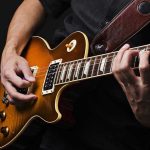 Rock Legend FOUND DEAD – Cause of Death Revealed! Hands playing an electric guitar.