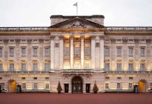 Royal Bloodline SHATTERED—Prince Banished Forever Front view of Buckingham Palace with illuminated facade and British flag
