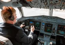 PAYLESS Pilots – Shutdown Pushes Airlines to Brink Pilot in cockpit operating airplane controls.