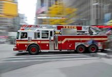 Red fire truck driving through city street crosswalk