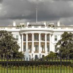 The White House with overcast sky and flag raised.