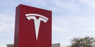 Tesla sign in front of dealership.