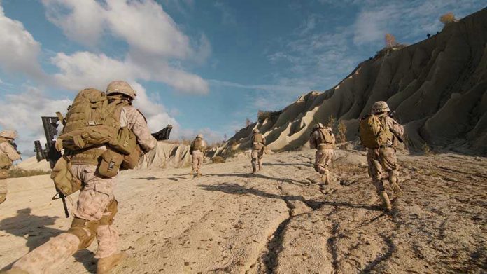 675995536 Soldiers running on rocky terrain with backpacks.