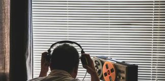 Person listening to a vintage tape recorder with headphones