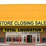 Exterior of a store with a large sign announcing a closing sale and total liquidation