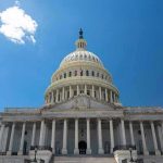 Congressional Hearing ERUPTS – Protestors RUSH IN! U.S. Capitol building against a clear blue sky.