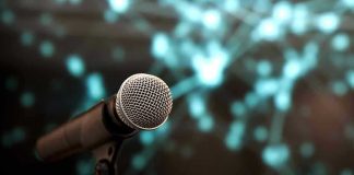 Microphone with abstract, blurred blue background.