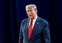 Trump’s TOP Aide BETRAYS Him – Writes Remarkable Memoire Man in suit with red tie speaking on stage.