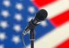 Microphone with blurred American flag background.
