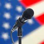 Microphone with blurred American flag background.