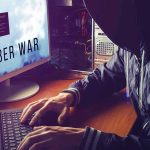 Hacker typing at desk with Cyber War screen.