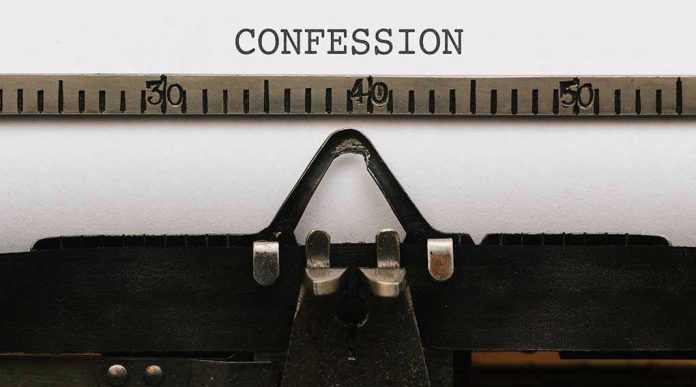 Typewriter typing the word confession on paper