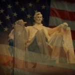Statue of Abraham Lincoln seated against a backdrop of the American flag