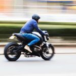 A person riding a motorcycle swiftly through an urban area