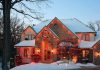 A beautifully decorated house with Christmas lights in a snowy setting