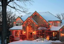 A beautifully decorated house with Christmas lights in a snowy setting