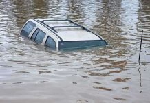 BREAKING: Governor Declares Emergency – 100,000 EVACUATED! A partially submerged vehicle in floodwaters