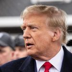 Trump Fuels ISIS Fire With Latest Strike Man in suit and red tie speaking outside.