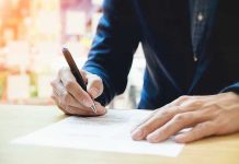 Voter ID Petition Gains Record Support – See Who Signed! Person signing a document with a pen.