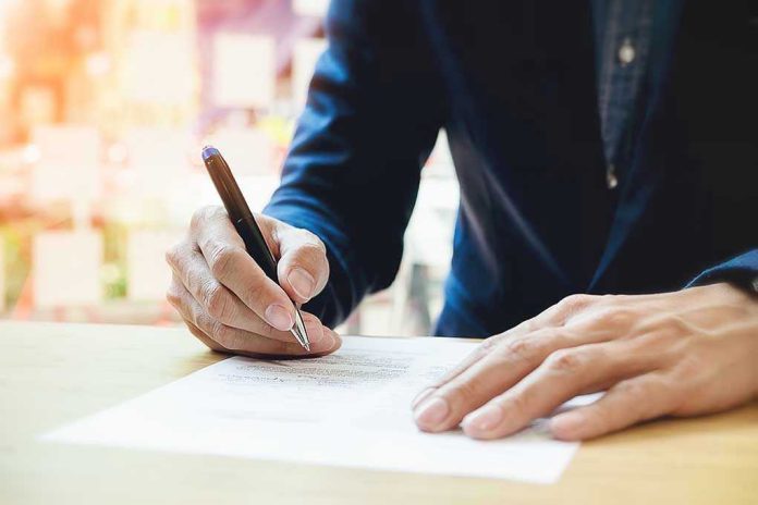 Person signing a document with a pen.