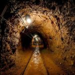 CATASTROPHIC Mine Collapse Kills 200 — Rebels Rake In Cash Dimly lit underground tunnel with rail tracks and rocky walls