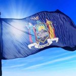 Mamdani’s Top Appointee Blasts Home Ownership as ‘White Supremacy’ New York state flag waving against a blue sky