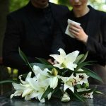 Iconic ’80s Actress DIES After Secret Cancer Fight Mourners in black holding white flowers at funeral.
