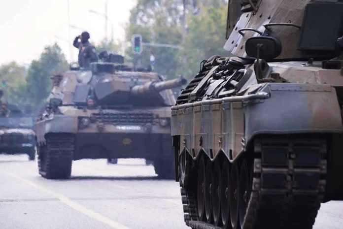 Tanks on a road with soldiers inside.