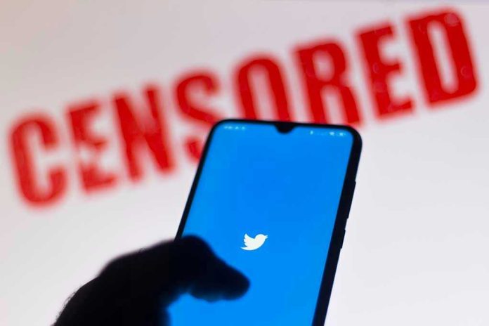 Phone displaying Twitter app with CENSORED in background.